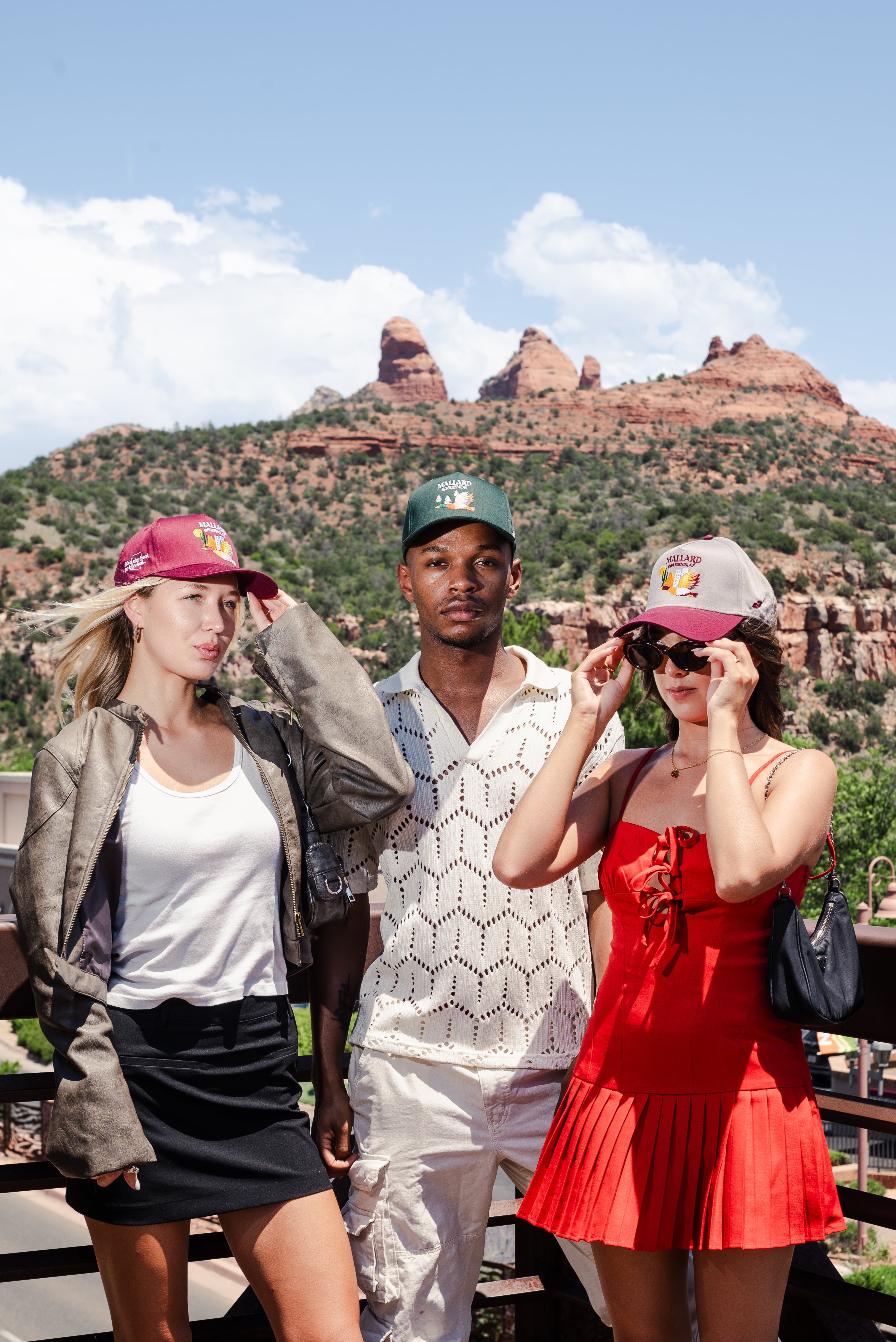 Two women and one man wearing Mallard and Friends Five Panel Hats with a canyon in the background mobile version