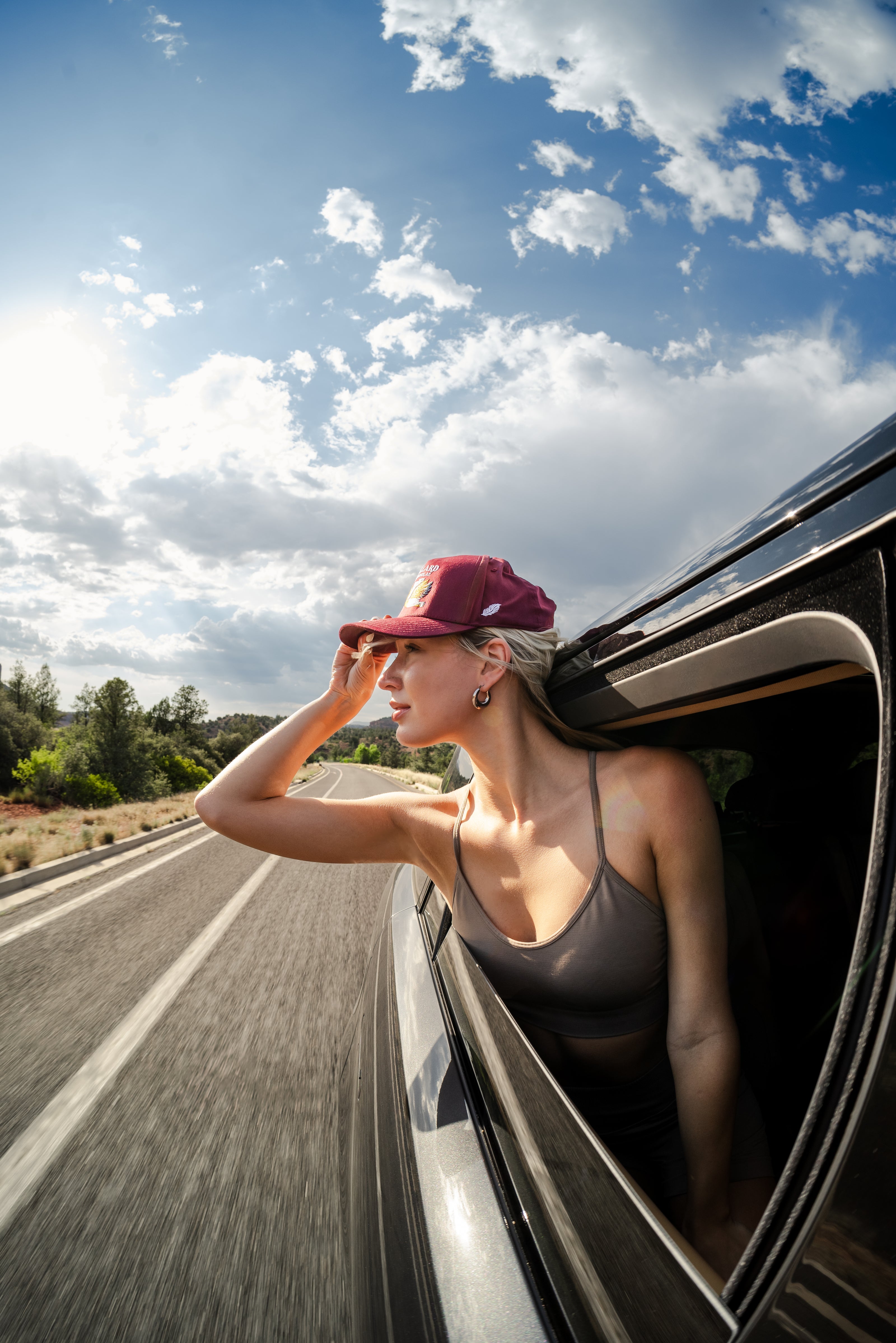 Woman peeking through a car window wearing Mallard and Friends Maroon Five Panel Hat