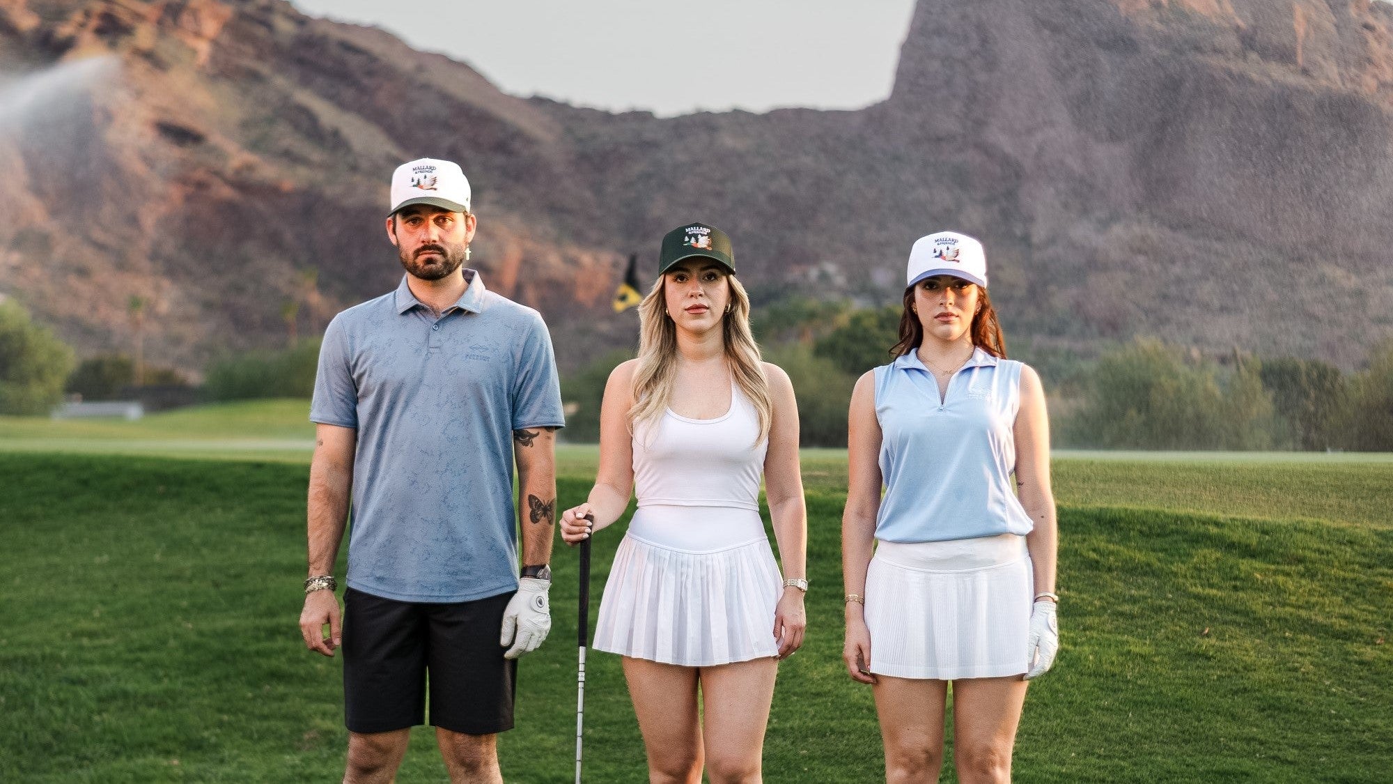 Three friends at a golf course wearing Mallard and Friends Premium Five Panel Hats 