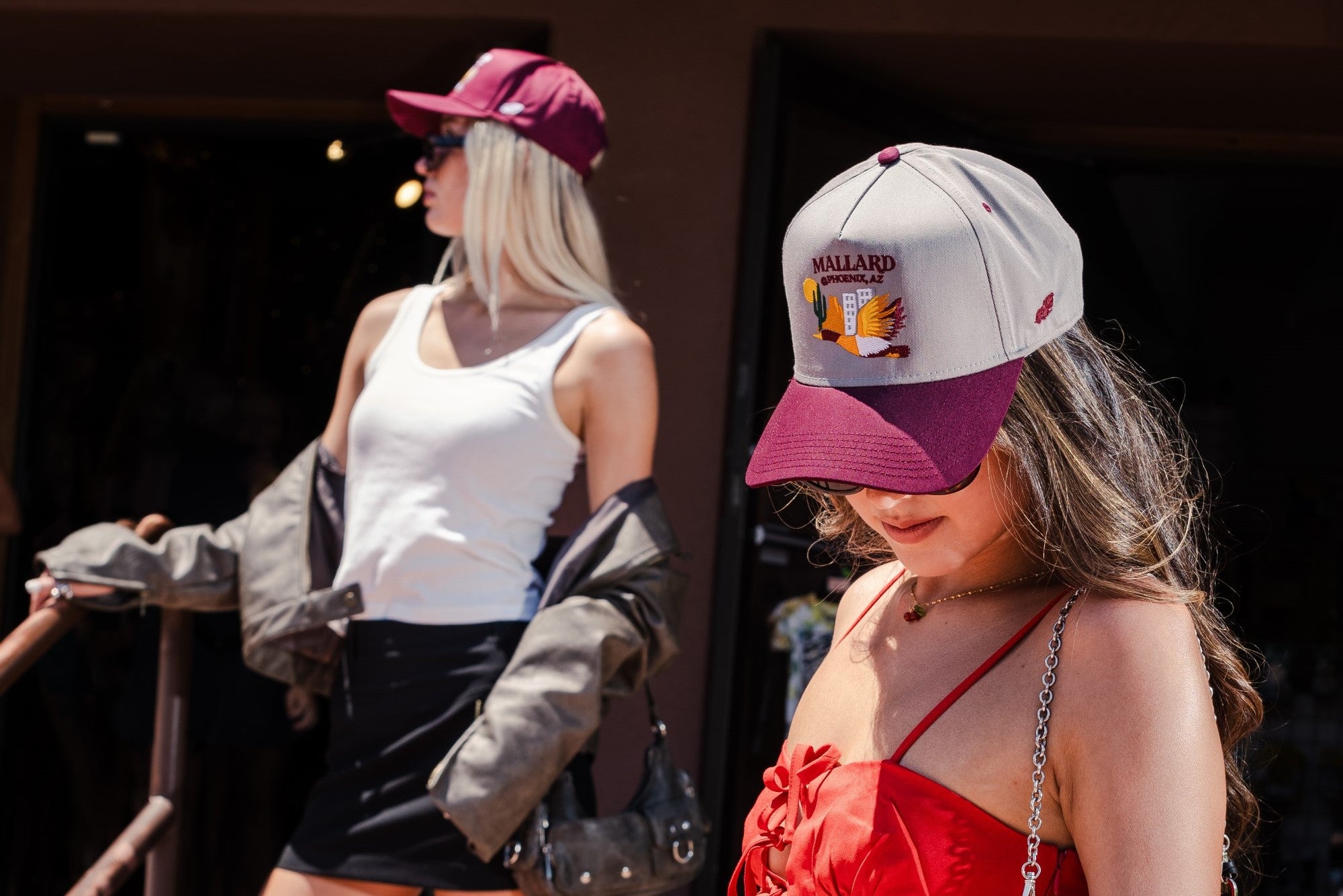 Two women posing with Mallard and Friends Hats featuring Phoenix, AZ Drop